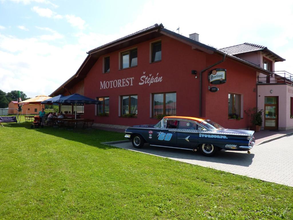 an old car parked in front of a red building at Motorest Štěpán in Těšov