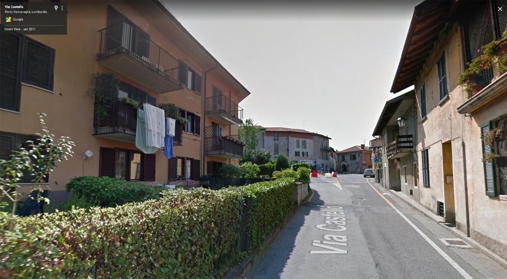 an empty street with buildings and a fence at Piccola casa vacanze - Small vacation house in Porto Valtravaglia