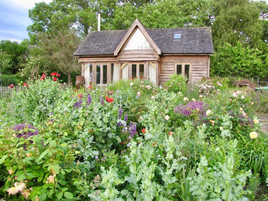 een tuin voor een klein huis met bloemen bij Barrington Barn in Barrington