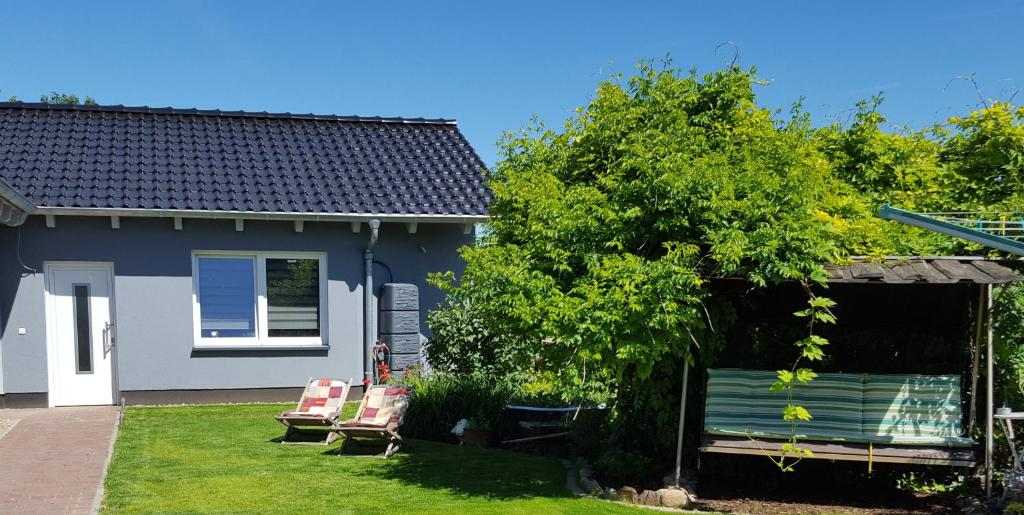 a house with two chairs and a bench in the yard at Clara Hills in Eberswalde