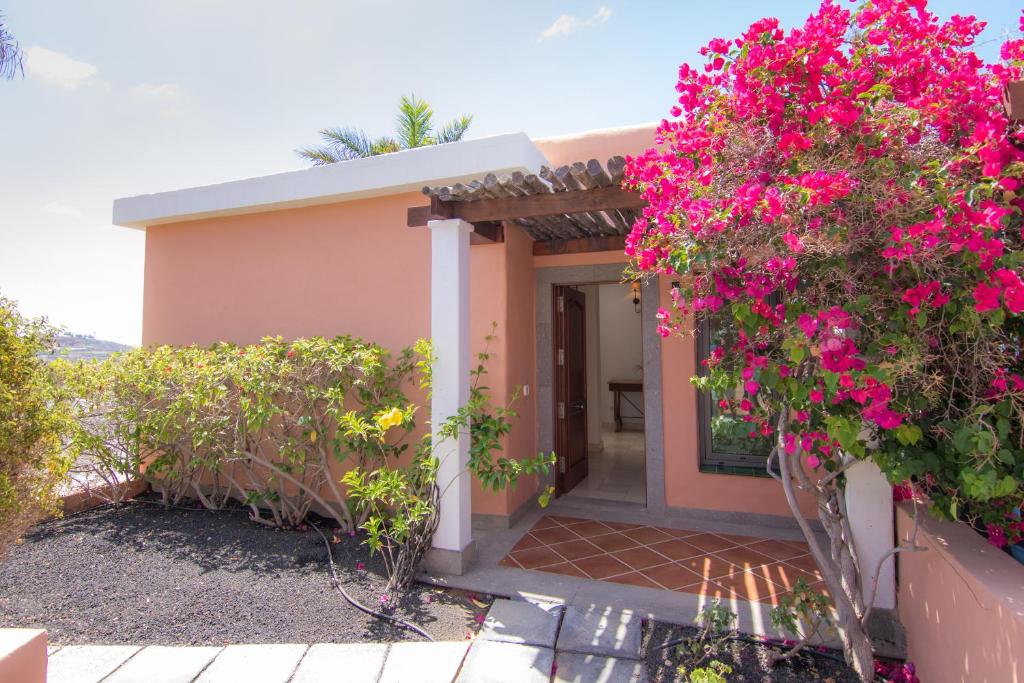 dom z różowymi kwiatami na boku w obiekcie HomeForGuest SALOBRE GOLF VILLA, POOL, BBQ, WIFI, STUNNING VIEWS w mieście San Bartolomé