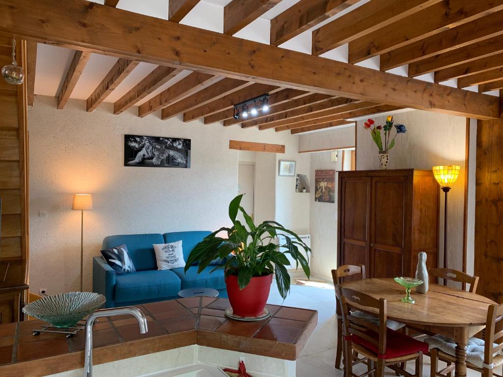 a living room with a blue couch and a table at Gîte Chablisien in Chablis
