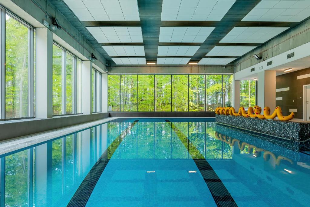 uma piscina com cadeiras laranja e janelas em Apartamenty Aquamarina Onyx by Renters em Międzyzdroje