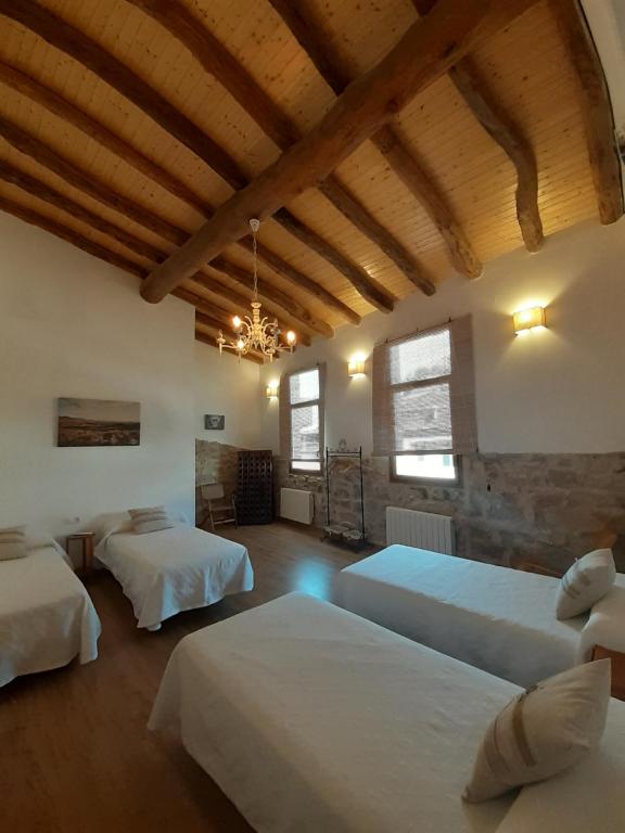 a bedroom with two beds in a room with wooden ceilings at Casa La Foradada in Corbera