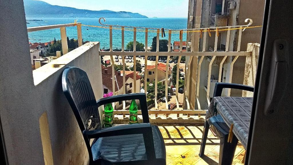 a balcony with a table and chairs and the ocean at Apartman Ana in Igalo