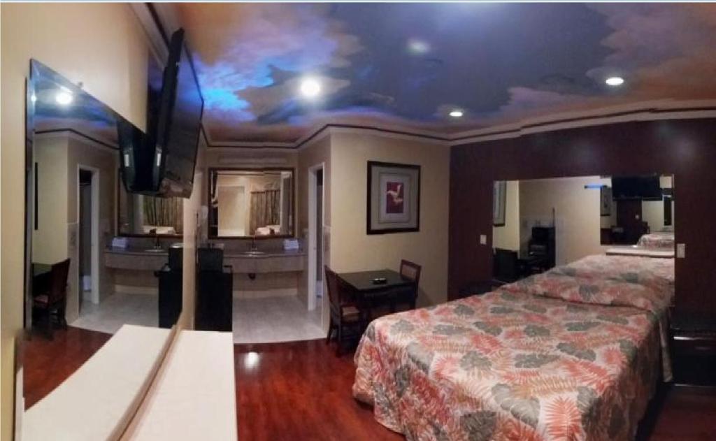 長灘的住宿－科爾尼汽車旅館，配有一张床和一台平面电视的酒店客房