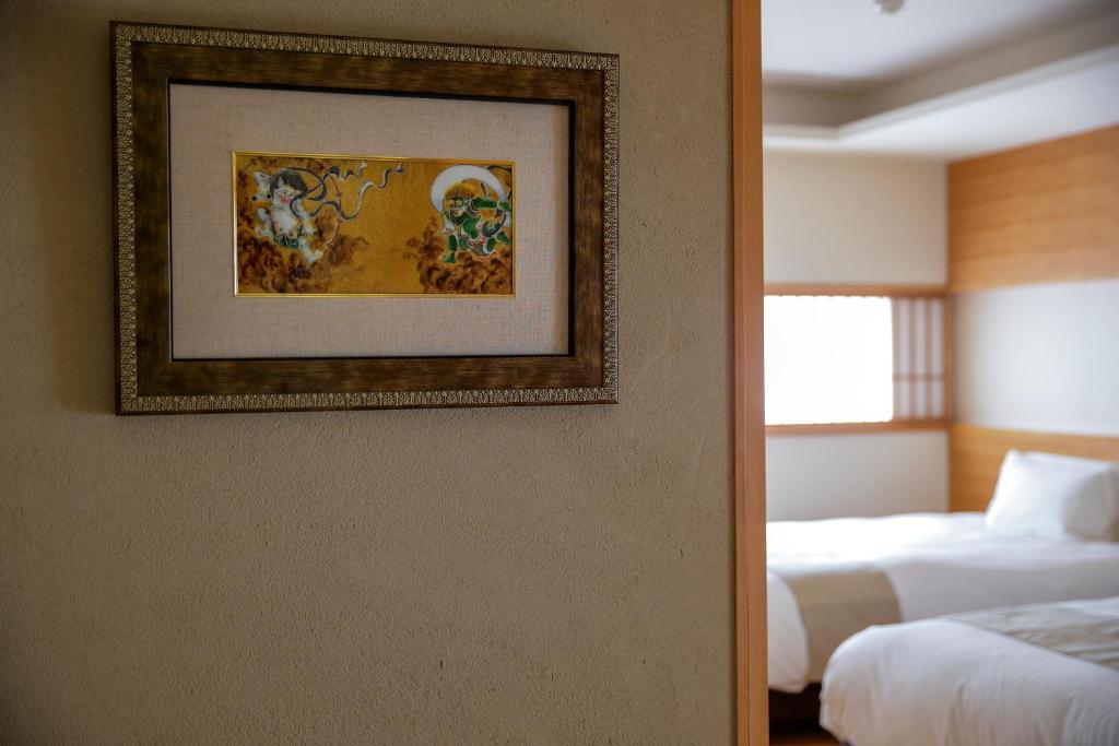 Postel nebo postele na pokoji v ubytování Kaminarimon Ryokan