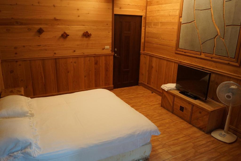 a bedroom with a bed and a tv in it at Spring Ground Resort in Ren&#39;ai