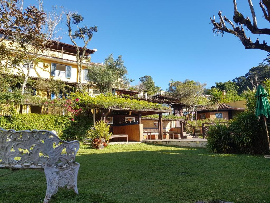 a park bench in front of a house at Pousada 14 Bis in Petrópolis