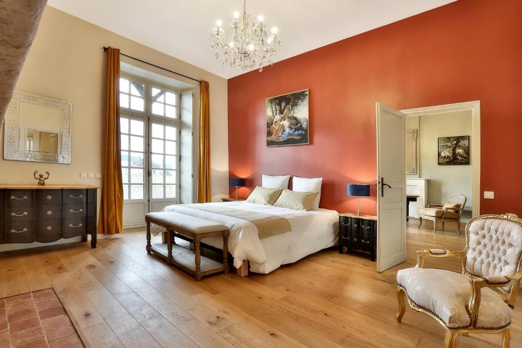 a bedroom with a large bed and a chandelier at La Maison des Consuls in Périgueux