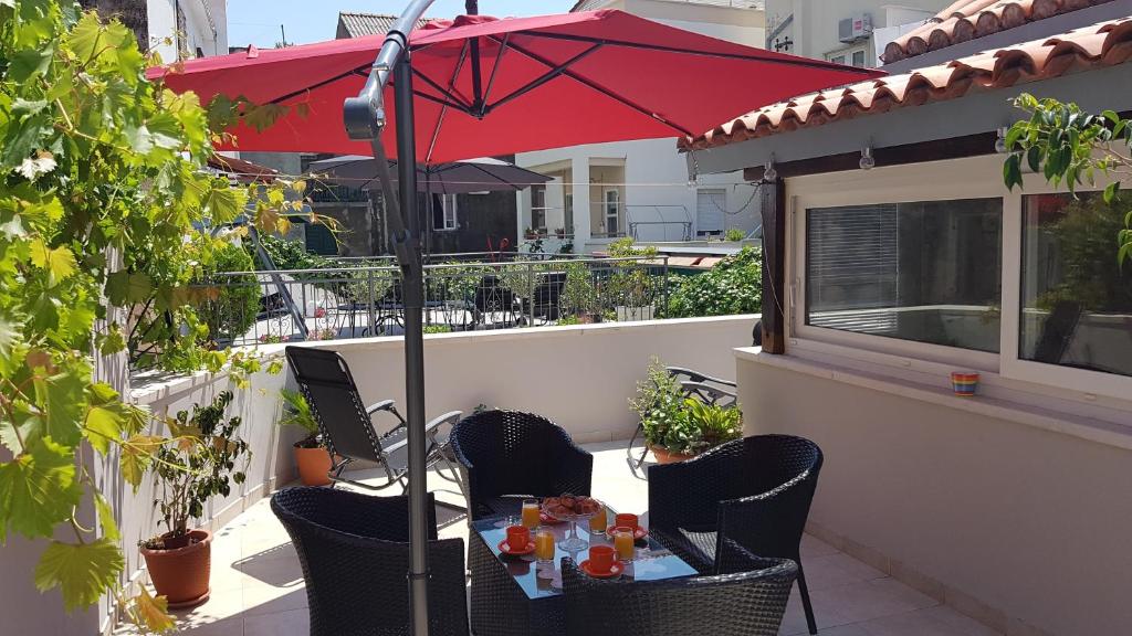 a table with a red umbrella on a balcony at Apartment 22 Omiš in Omiš