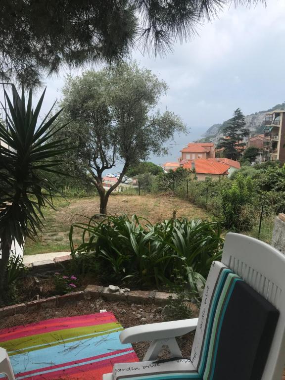 a patio with a chair and a view of a yard at Casa del sasso in Bergeggi