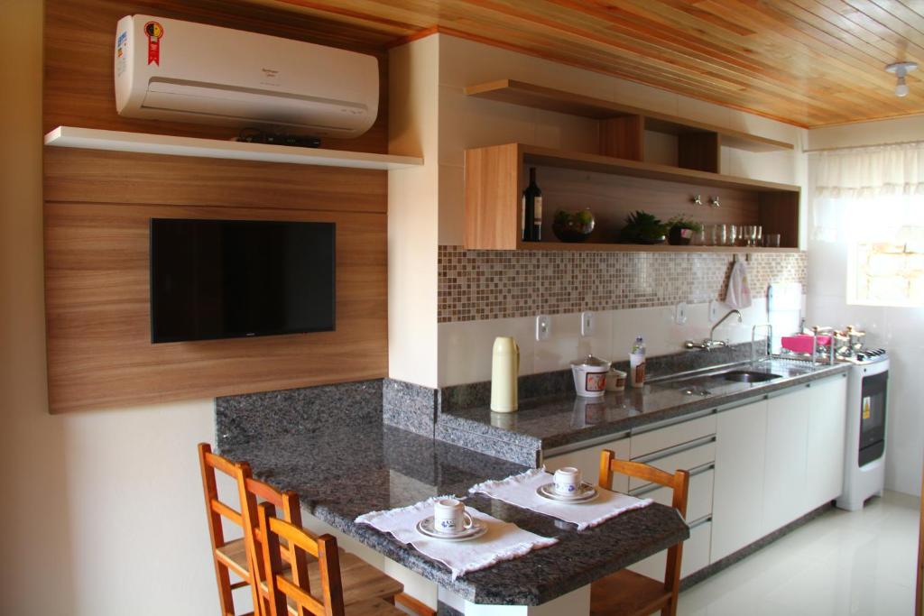 uma cozinha com um lavatório e uma bancada em Apartamento Serrano em São Joaquim