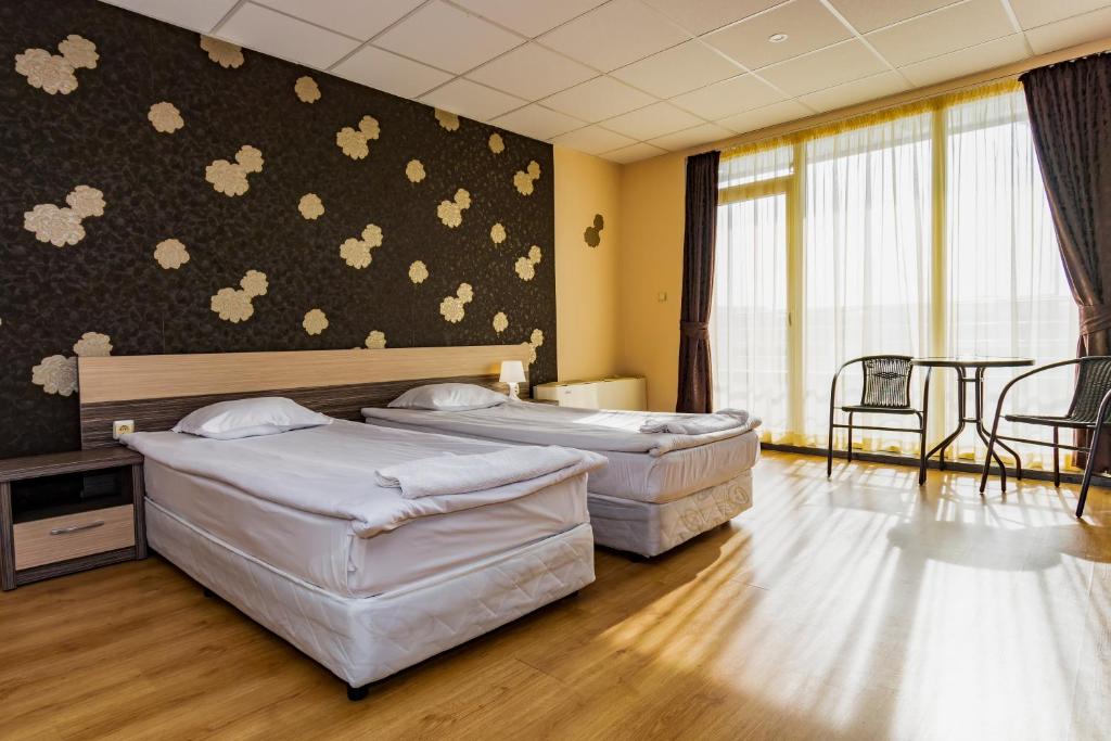 a hotel room with two beds and a table at Hotel City in Burgas