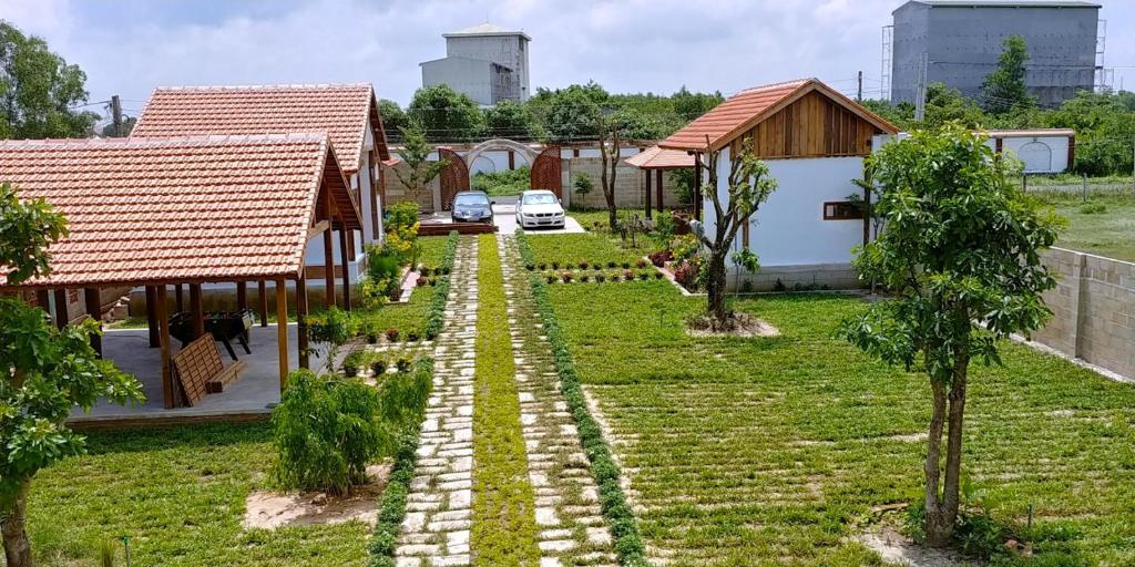 a garden with a pathway between two houses at CocoPalm Villa near Beach - Mango room in Hội Mỹ