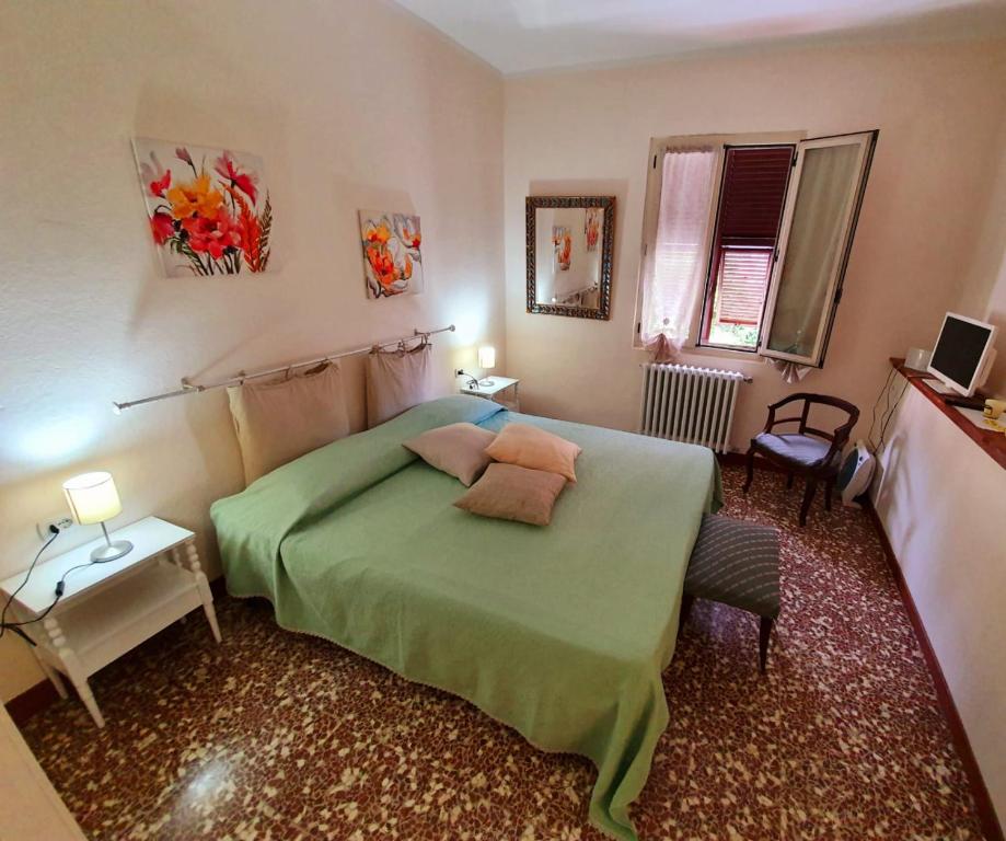 sypialnia z zielonym łóżkiem z 2 poduszkami w obiekcie Il Girasole ...At Andorus' House w mieście Erli