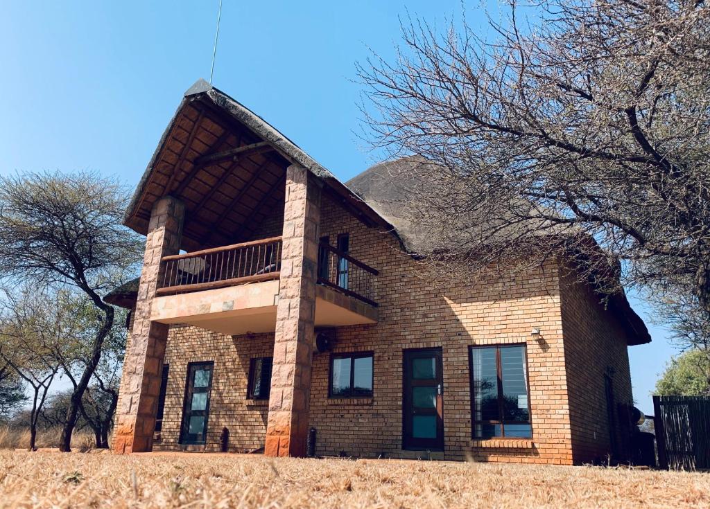 uma grande casa de tijolos com um telhado de gambrel em Makhato Bush Lodge 111 em Bela-Bela