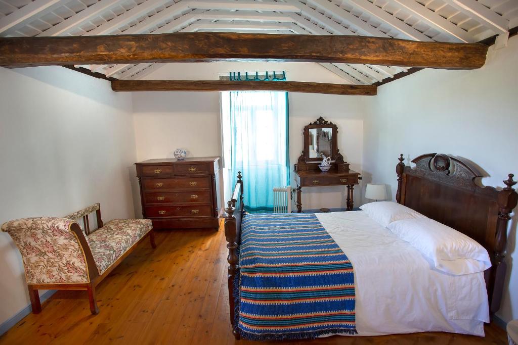 a bedroom with a bed and a chair and a window at Casa Rotas a Nordeste in Nordeste
