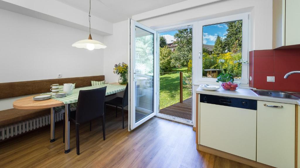 a kitchen with a table and a dining room at AppartChalet LA RONDULA - 100m from Seceda in Ortisei
