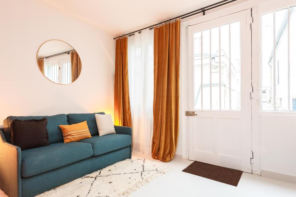 Beaumarchais في باريس: غرفة معيشة مع أريكة زرقاء أمام باب