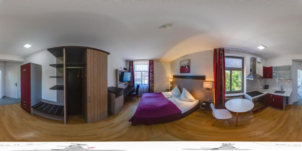 - un salon avec une chambre dotée d'un lit et d'une table dans l'établissement Alpina home, à Rosenheim