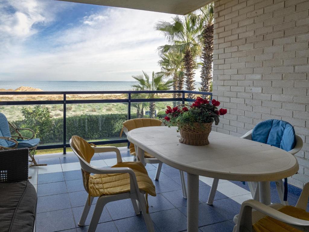 a table and chairs on a balcony with a view of the ocean at Dorasal Solo Familias Serviplaya in Playa de Xeraco