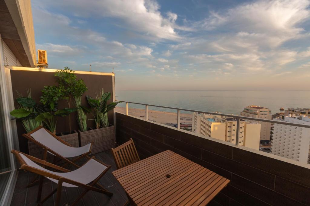 d'un balcon avec une table et des chaises donnant sur l'océan. dans l'établissement SOLARIS PANORAMIC studio vue mer, à Portimão