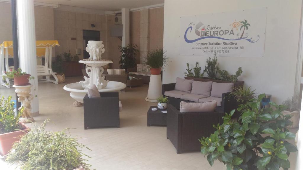 Residence Europa في ألبا أدرياتيكا: غرفة معيشة مليئة بالكثير من النباتات الفخارية