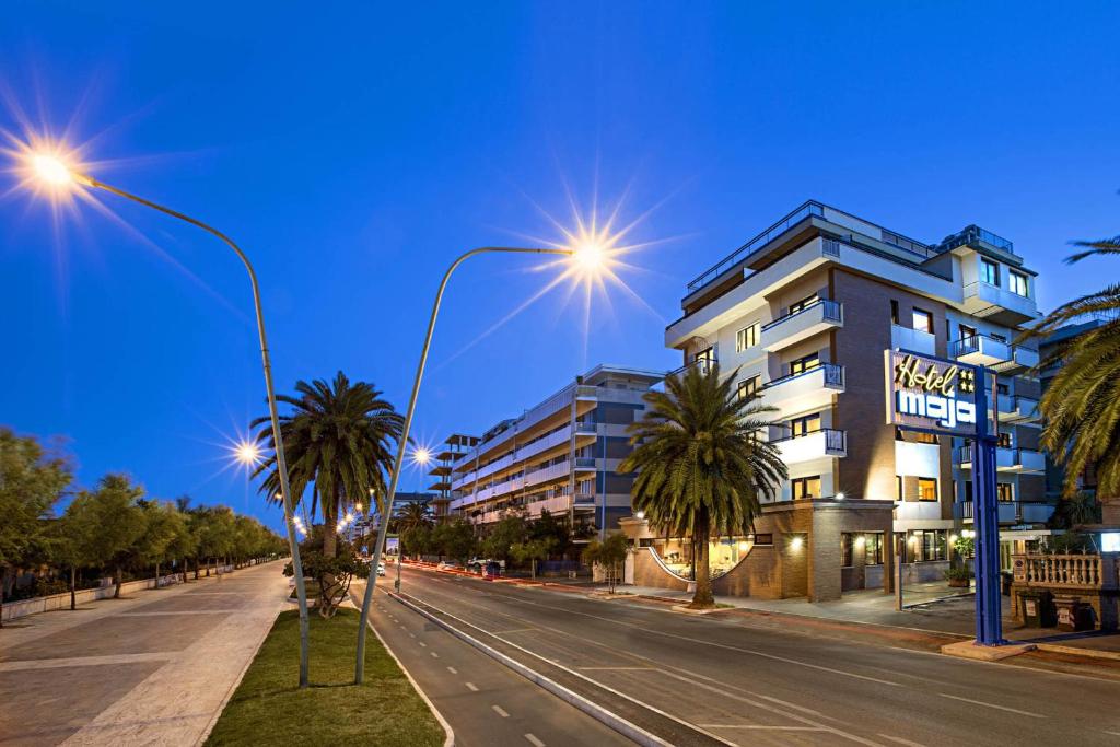 una strada con palme di fronte a un edificio di Hotel Maja a Pescara