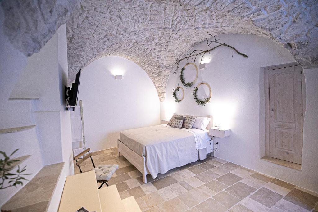een slaapkamer met een bed in een kamer met een stenen muur bij Radici Ostuni in Ostuni