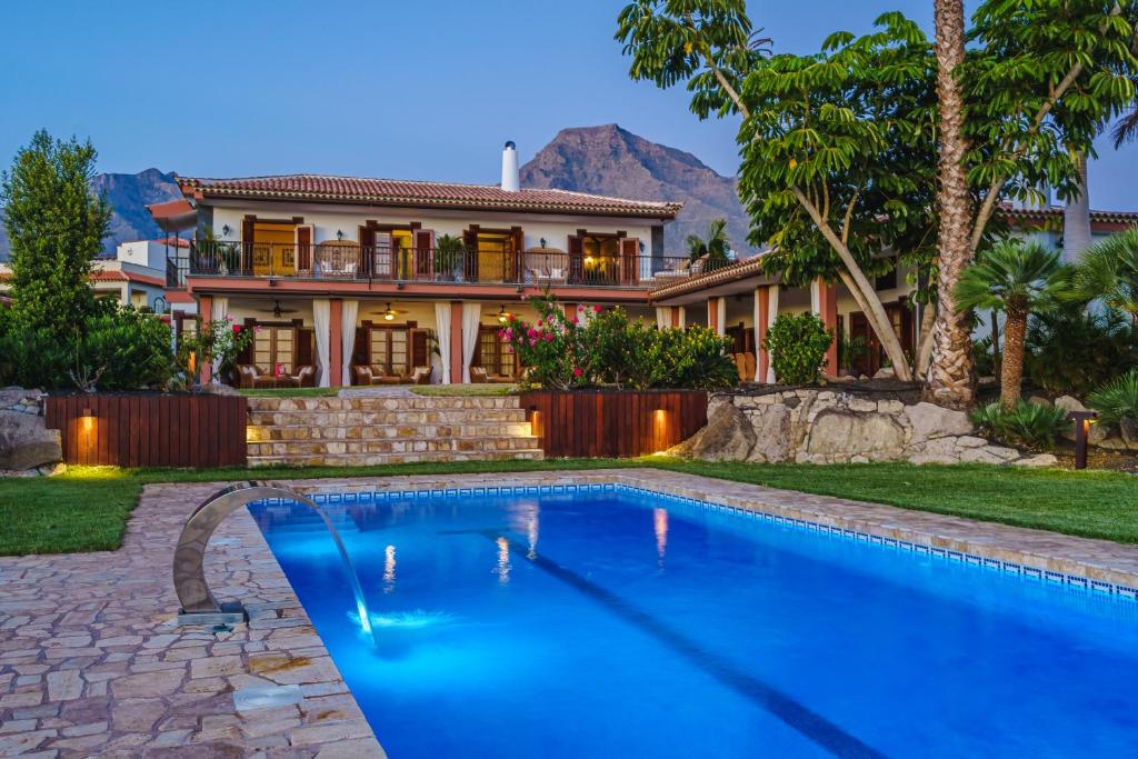 ein Haus mit einem Pool vor einem Haus in der Unterkunft Finca La Rosa de Los Vientos in Adeje