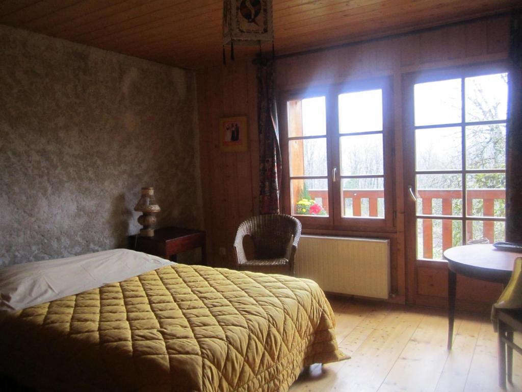 een slaapkamer met een bed en een groot raam bij Crouzet in Crouzet-Migette