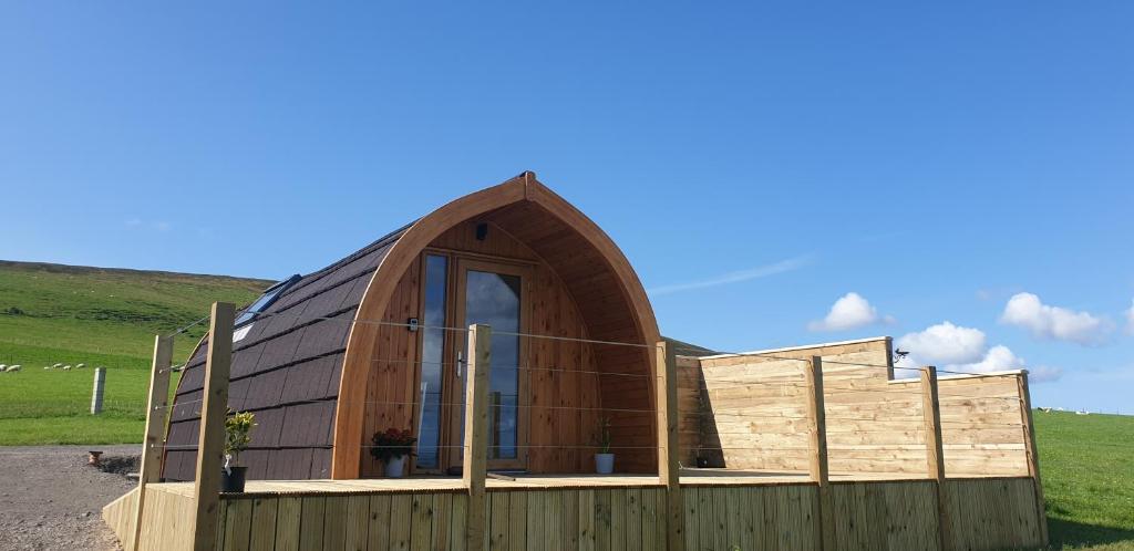 una casa circular con una valla de madera en Lilly's Lodges Orkney Butterfly Lodge, en Finstown