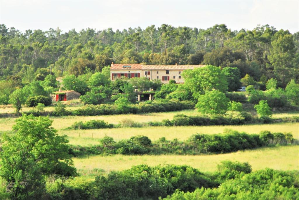 une maison au milieu d'un champ avec des arbres dans l'établissement Domaine Saint-Jaume gîte Muscat, à Barjols