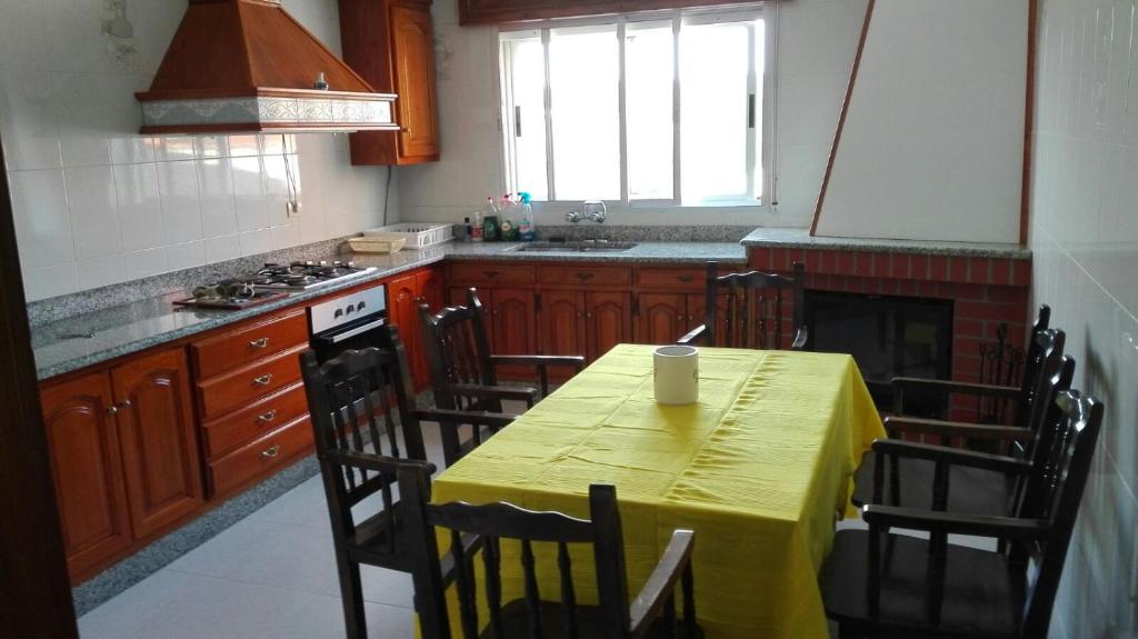 een keuken met een tafel met een gele tafelkleed erop bij casa cachafeiro in Rodeiro