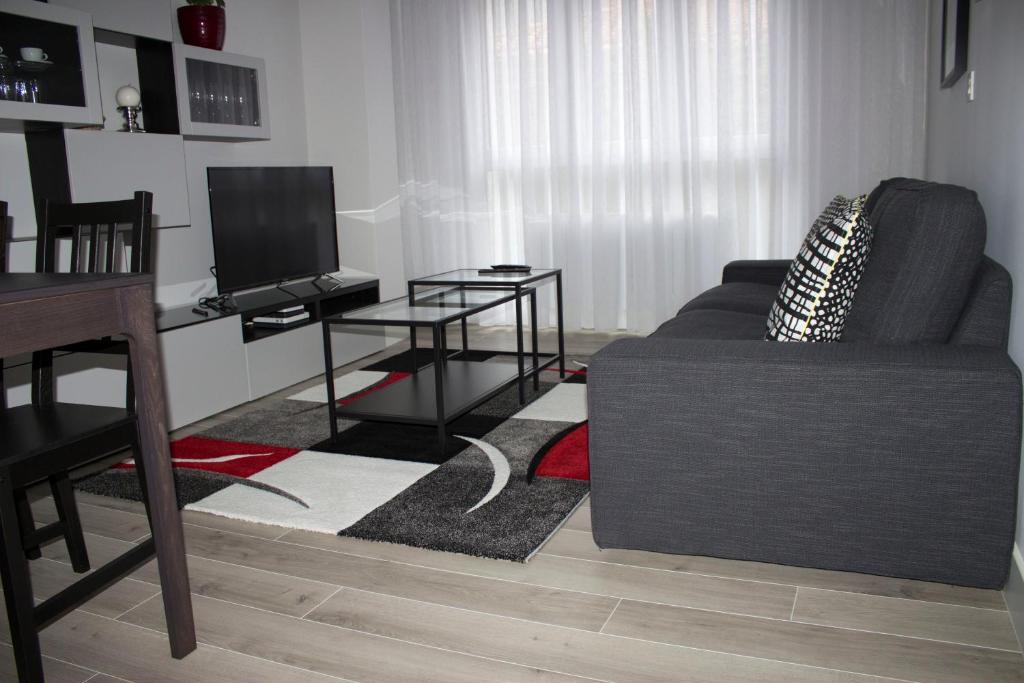 sala de estar con sofá y TV en IZASKUNena Home E-BI 1190, en Getxo