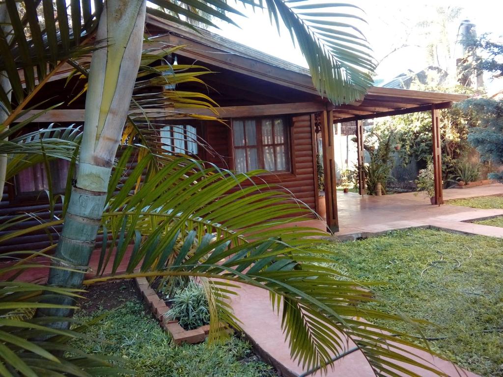 uma casa com uma palmeira em frente em IGUAZU CABANAS em Puerto Iguazú