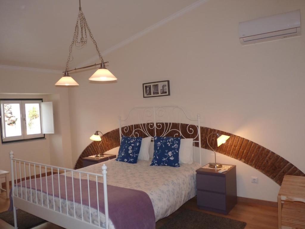 sypialnia z dużym łóżkiem z niebieskimi poduszkami w obiekcie Páteo dos Oliveira - Casa dos Serviçais w mieście Évora