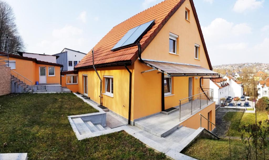 a yellow house with a red roof at A Spacious 3 Bedroom Apartment in Bad Abbach/Regensburg in Bad Abbach