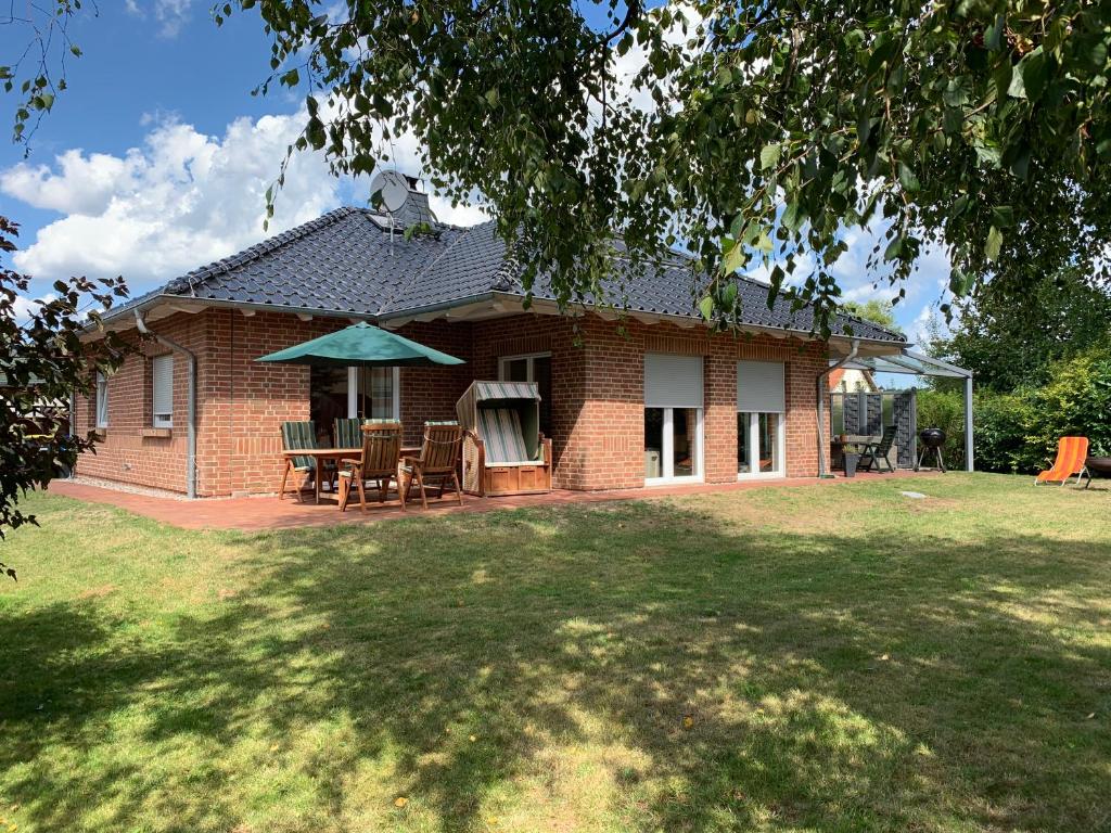 a brick house with a table and chairs in a yard at Feriendomizil-Stegemann in Trassenheide