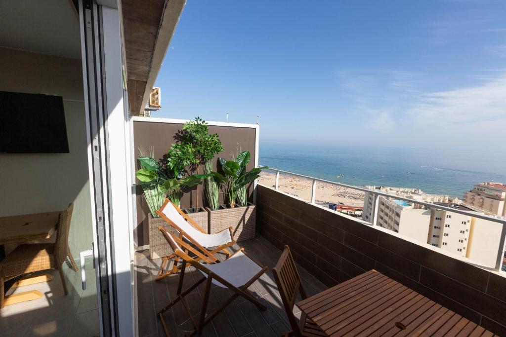 a balcony with two chairs and a view of the ocean at SOLARIS PANORAMIC studio vue mer in Portimão