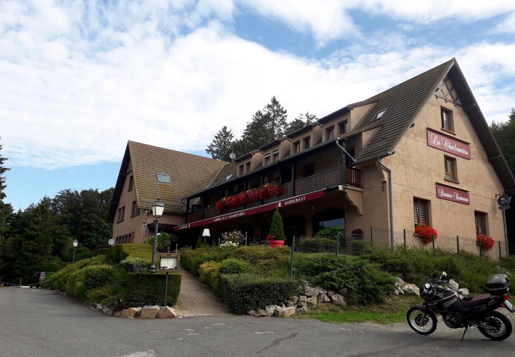 un bâtiment avec une moto garée devant lui dans l'établissement Appartement la Charbonnière, à Bellefosse