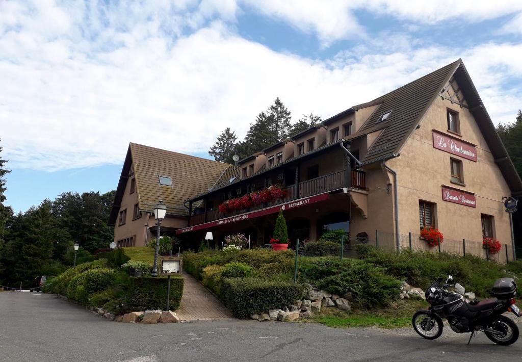Un edificio con una motocicleta estacionada enfrente. en Appartement la Charbonnière, en Bellefosse
