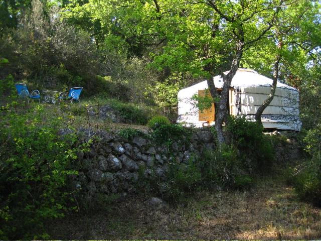 a white trailer parked in a field with two chairs at Le Mas Nomade in Callian