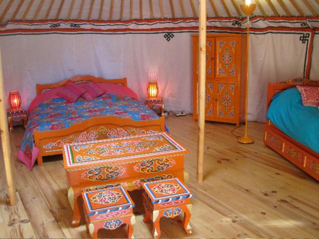 a bedroom with two beds and two tables in it at Le Mas Nomade in Callian