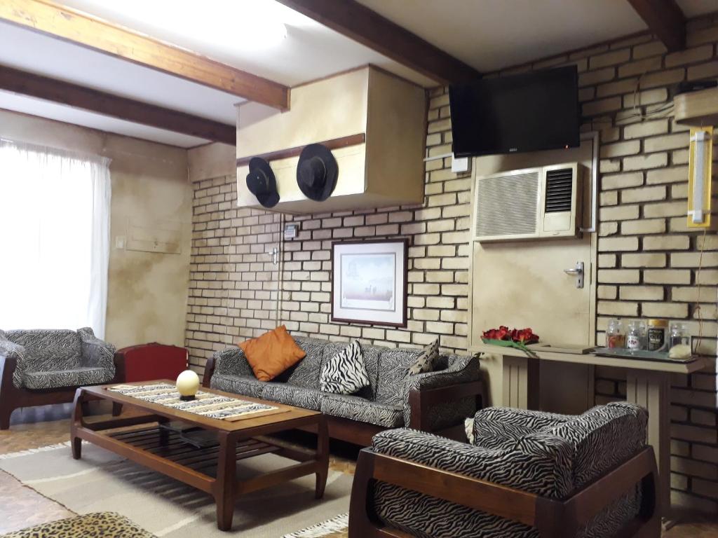 a living room with a couch and a table at Die Plasie Two-Bedroom Flat in Hartbeespoort
