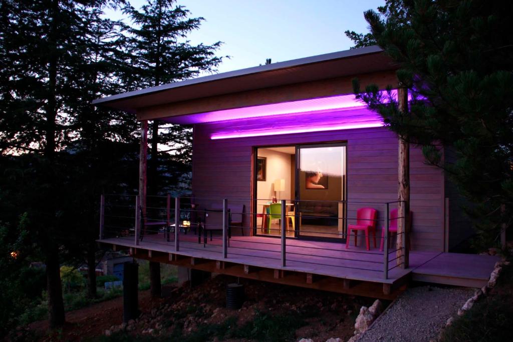 una casita púrpura con luces rosas. en Gîte La Cerise Qui Rit, en La Cresse