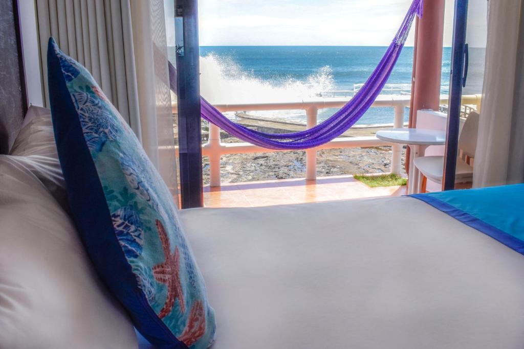 um sofá com almofadas e vista para o oceano em Mar & Sol, Hotel y resturante em La Unión