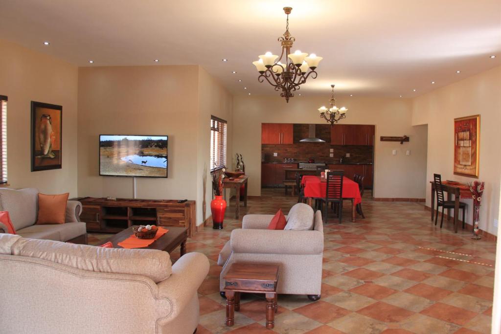 a living room with couches and a dining room at Hornbills Rest Country Home in Phalaborwa
