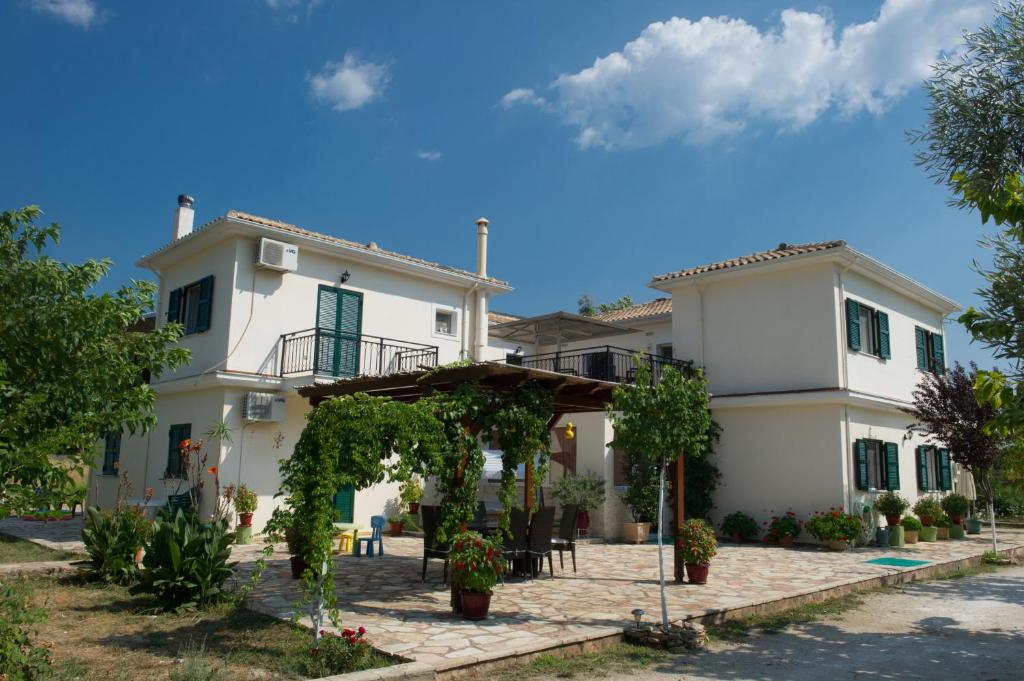 a large white house with a patio in front of it at Riverside Αpartments in Vasiliki